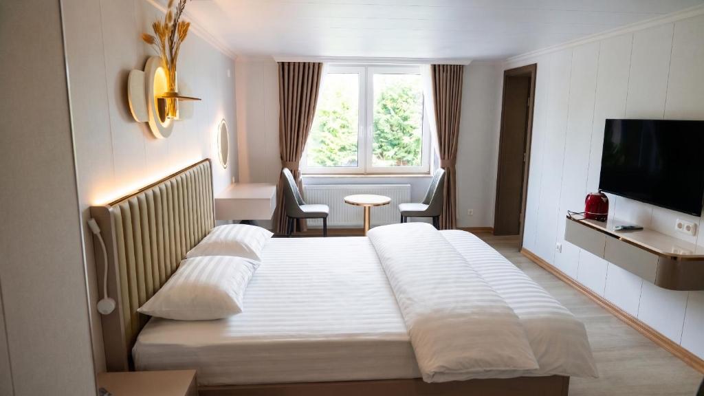 ein Hotelzimmer mit Bett und Fernseher in der Unterkunft Zen Garten in Ahrensfelde