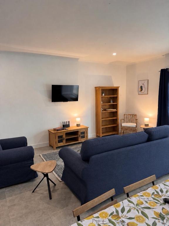 a living room with two blue couches and a tv at The Nook, Lourinha in Lourinhã