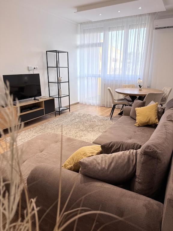 a living room with a couch and a table at Sarah Doe Apartman in Nyíregyháza