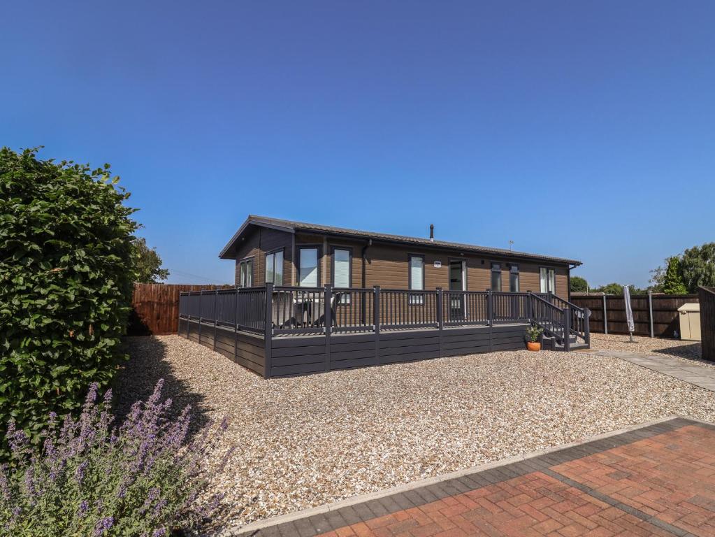 a house with a large deck on a gravel yard at Hazelwood 3 in Lyme Regis
