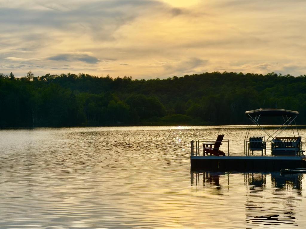 a boat sitting in the middle of a lake at Hotel Lac Carling Spa Golf in Harrington