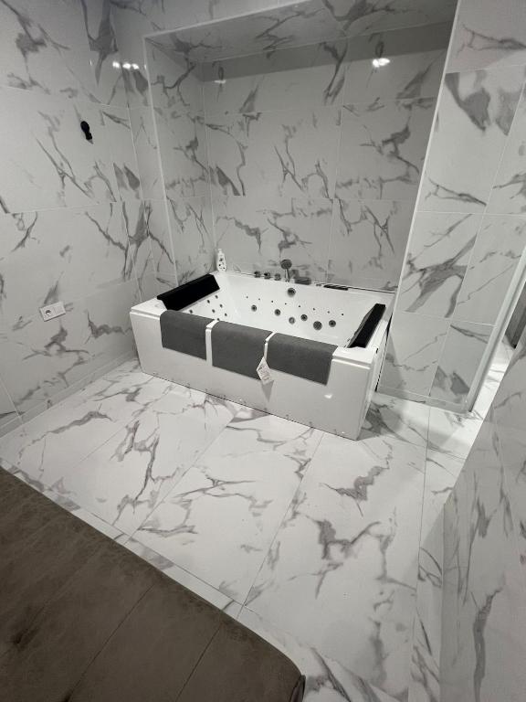 a bathroom with a bath tub on a marble wall at Gandía Jacuzzi Suites in Gandía
