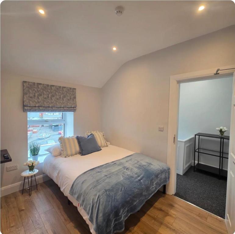 a bedroom with a large bed and a window at Newly Refurbished Townhouse in Derry Londonderry
