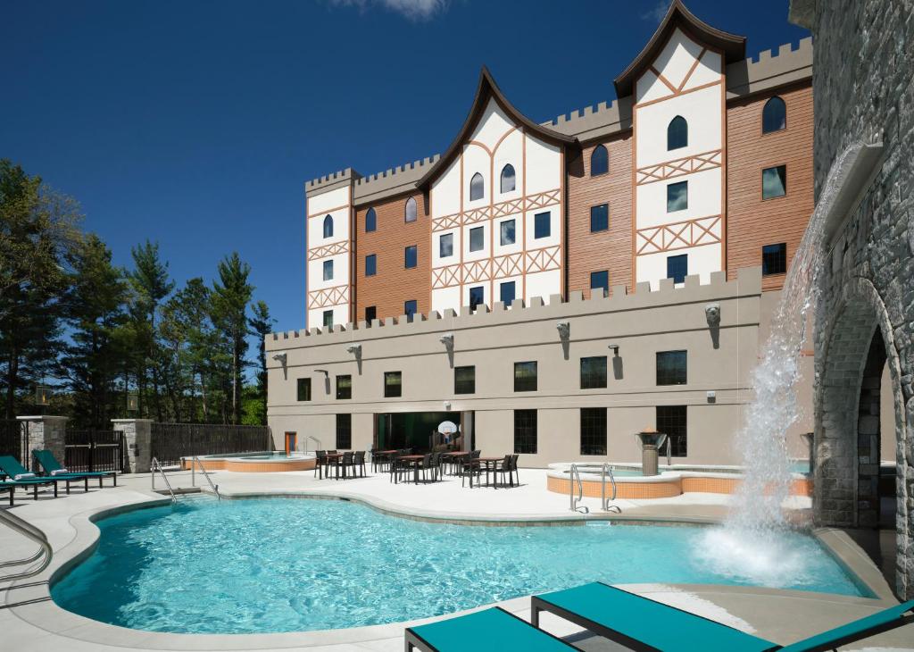 a large building with a swimming pool in front of it at Dellshire Resort in Wisconsin Dells