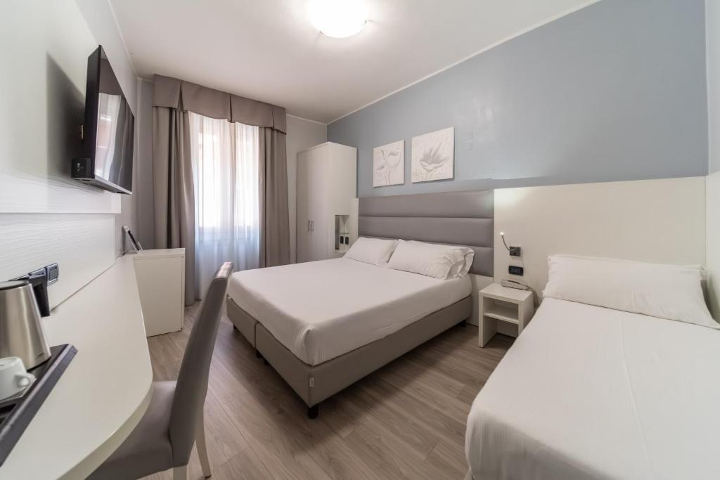 a hotel room with two beds and a television at Hotel University in Bologna
