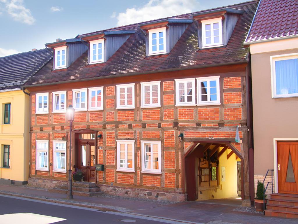 a red brick building with white windows on a street at Kleines Meer in Röbel