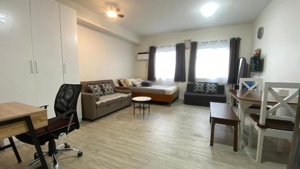 a living room with a couch and a table at Nuvali Studio Retreat Free Parking Fast WiFi Pool in Calamba