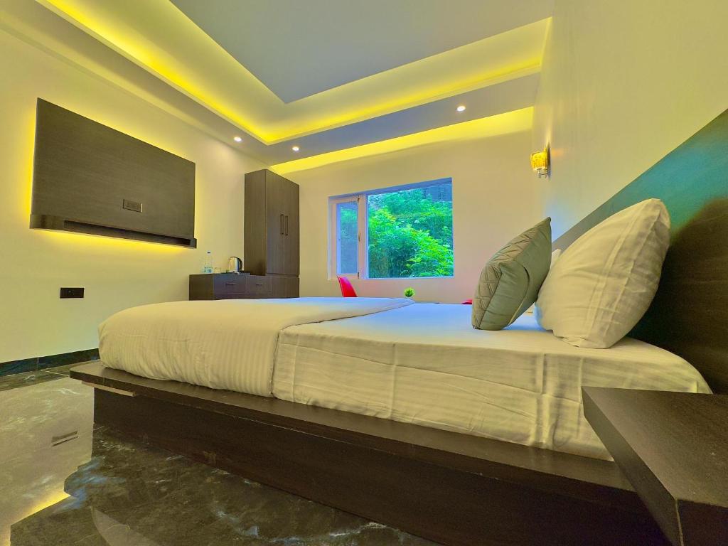 a bedroom with a large white bed with a window at Arkay Sonamarg in Sonāmarg