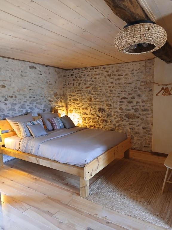 a bed in a room with a brick wall at La Parenthèse Béarnaise in Bonnut
