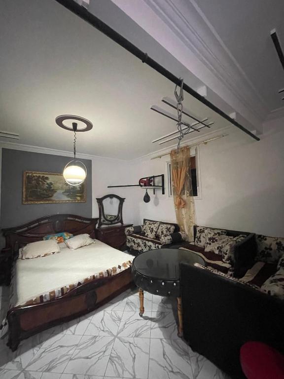 a bedroom with a bed and a couch at Grand Studio bien équipé in Oujda