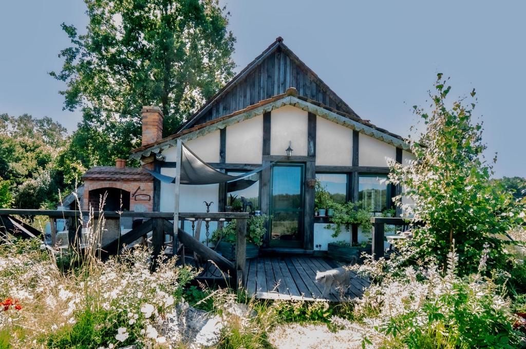 a small white house with a porch and windows at Koń na biegunach in Glaznoty