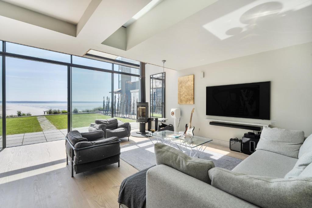 ein Wohnzimmer mit Sofa, Sesseln und Fernseher in der Unterkunft Beach House in Croyde