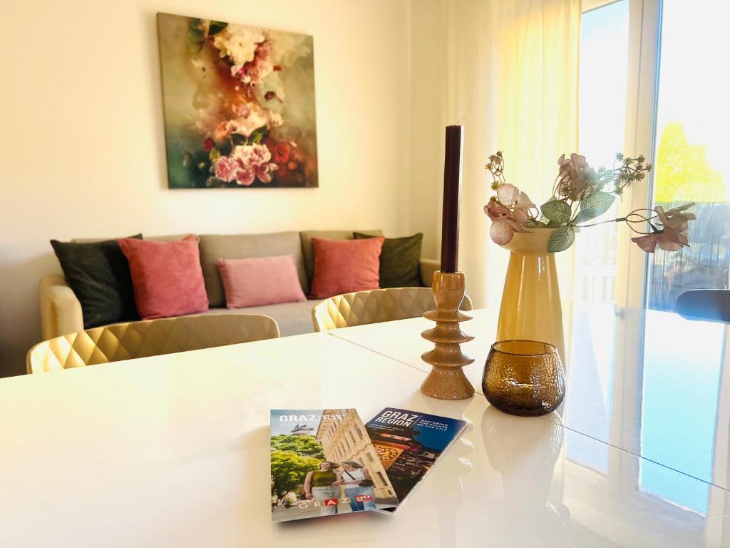 a living room with a table with a book and a vase at APSTAY Bungalow I Parking option & Self Check-in in Graz