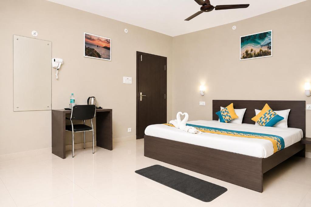 a bedroom with a bed and a desk in it at Vilasa Prime Hotel in Guwahati