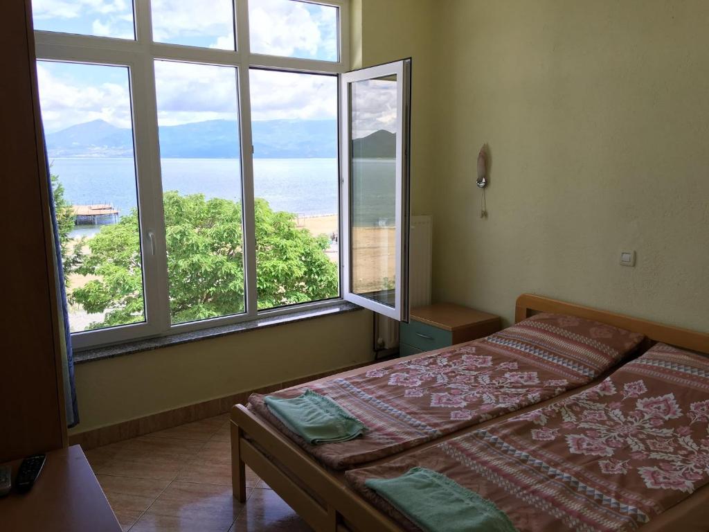 a bedroom with a bed and two large windows at Hotel Riva in Stenje