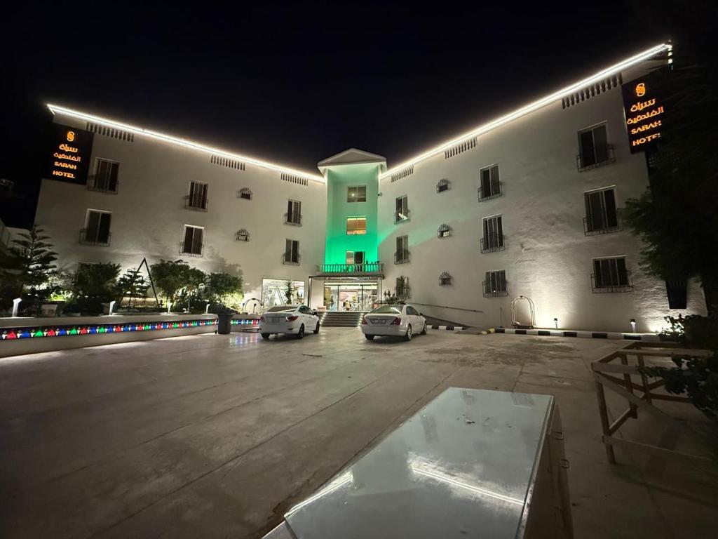 a large building with cars parked in a parking lot at سراة للشقق الفندقية in Al Namas