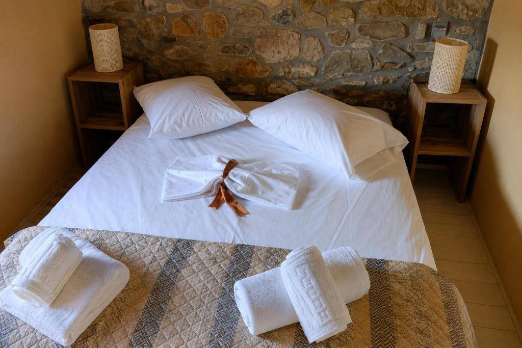 a bedroom with a white bed with towels on it at Thetis Stone Residence in Volissos