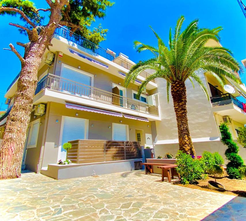 a building with two palm trees in front of it at Phoenix Garden Apartments - 4 - in Athens