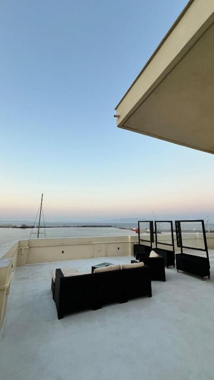 a room with couches and a view of the ocean at Rooftop View Chios in Chios