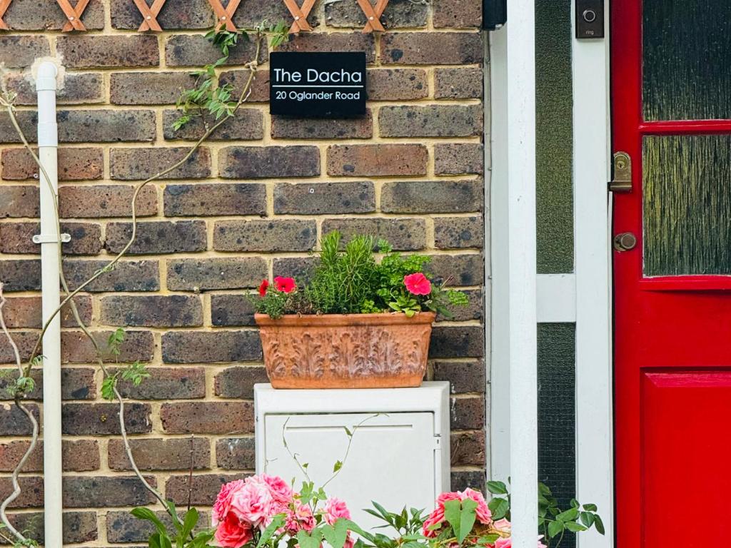 a potted plant on a white box next to a brick wall at The Dacha in Winchester
