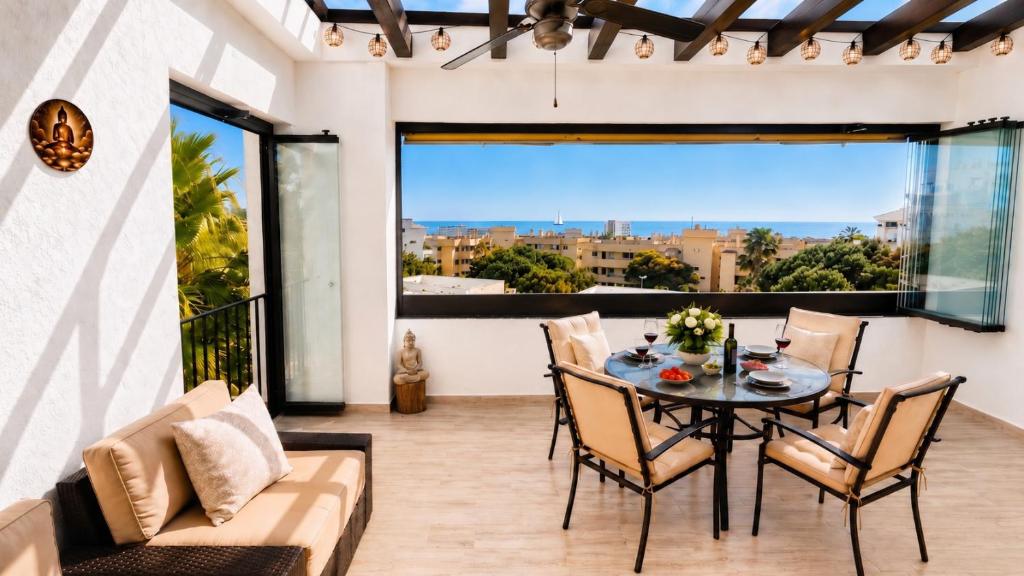 a dining room with a table and chairs and a large window at La Cala Center Premium Penthouse Motorized Terrace & Sea Views in La Cala de Mijas