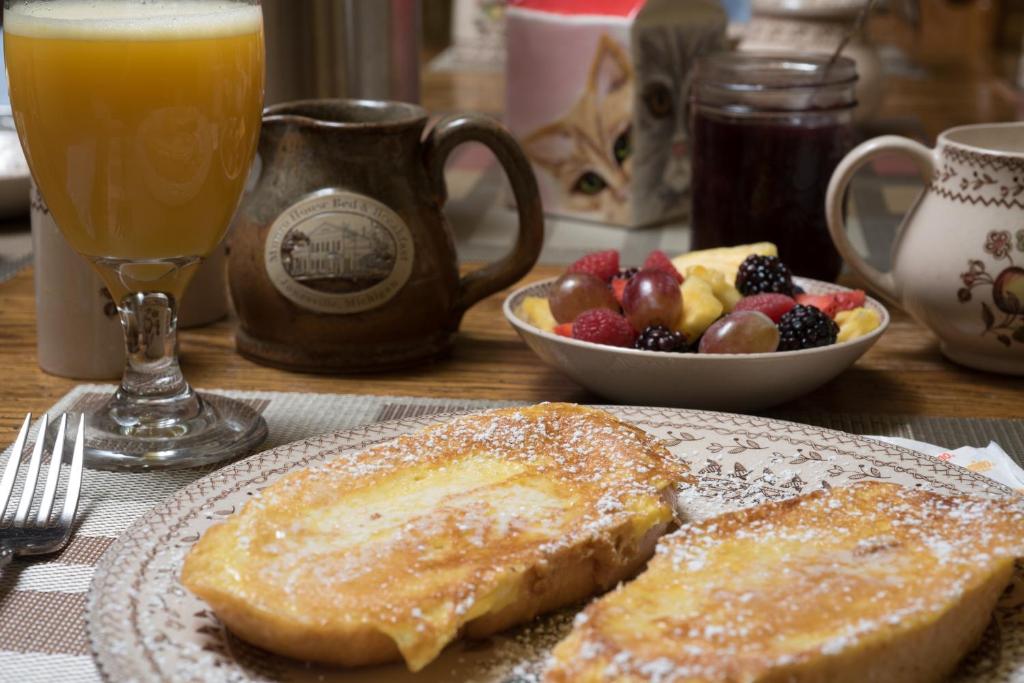 a table with a plate of french toast and a bowl of fruit at Munro House Bed and Breakfast in Jonesville