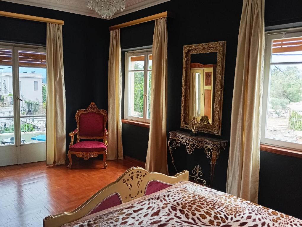 a bedroom with a bed and a chair and windows at IRIS baroque apartment in Eleusis