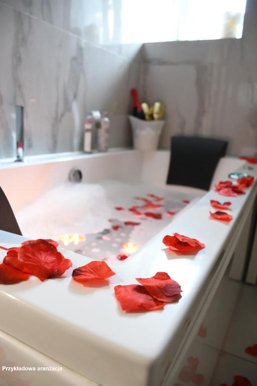 a white counter with red rose petals on it at Lemon & Jacuzzi in Boguszów-Gorce