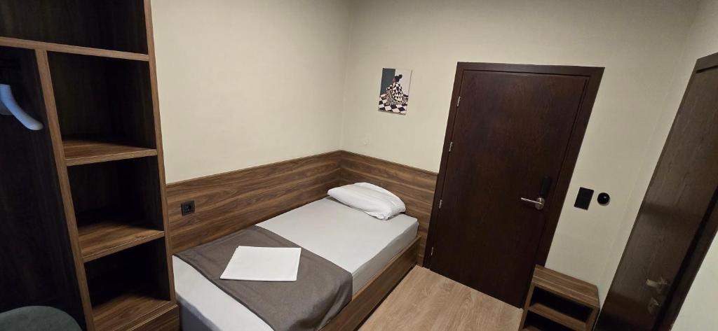 a small room with a small bed and a door at Drei Schweizer Hotel in Neuwied