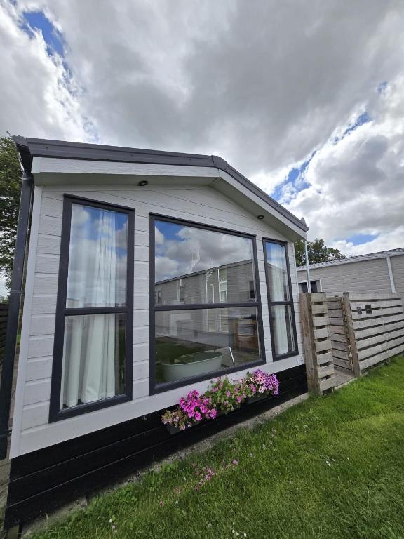 a small house with some flowers in a yard at PRACHTiG CHALET ZONNESTRAAL in Westerland