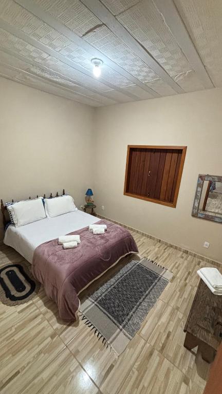 a bedroom with a large bed in a room at Alto do Paraíso Bichinho in Prados