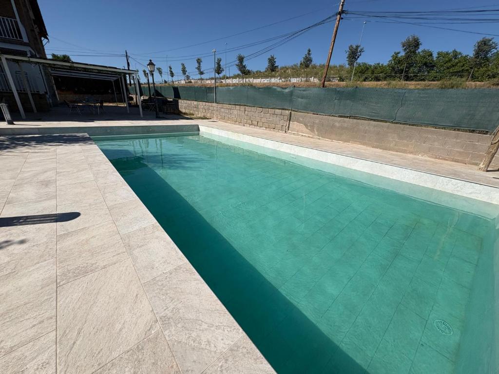 a swimming pool with turquoise blue water at Sueña Toledo- Apartamentos turisticos con piscina in Toledo