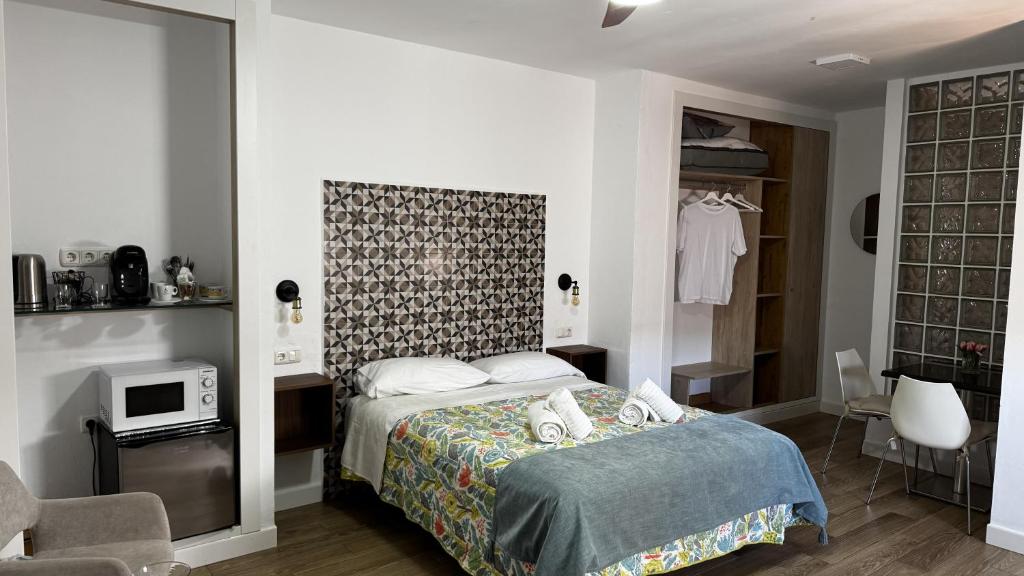 a bedroom with a bed and a chair in it at Patio de Los Barberos 3 in Valle de Abdalagís