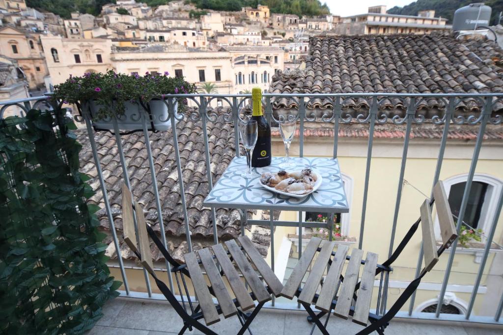 a bottle of wine sitting on a table on a balcony at Sinfonia Barocca in Modica