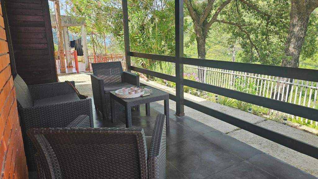a porch with two chairs and a table with a bowl on it at ČANJ Apartman Slavica in Čanj