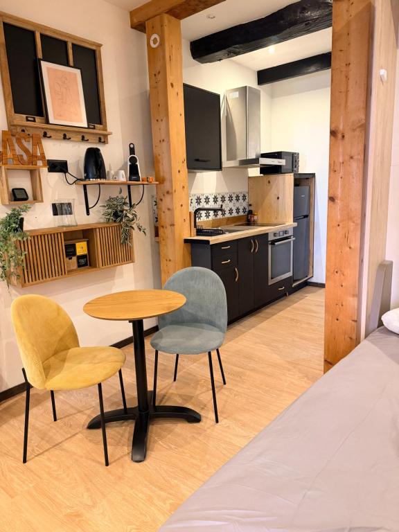 a room with a table and two chairs and a kitchen at Studio LA PETITE PAUSE in Ajaccio