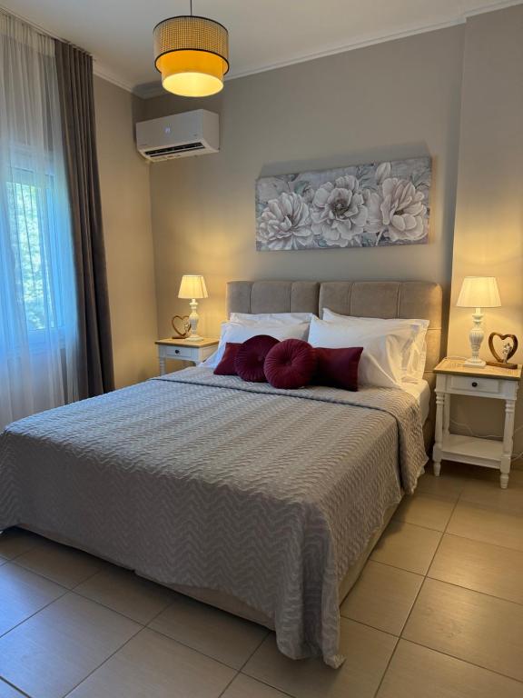 a bedroom with a large bed with red pillows at Marinas view apartment in Limenas