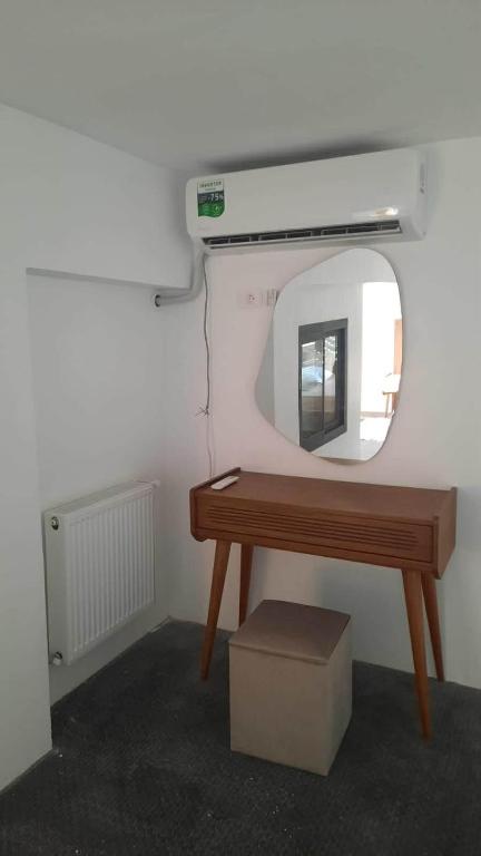 a mirror on a wall next to a wooden table at Elegant appartement in Hammam Sousse