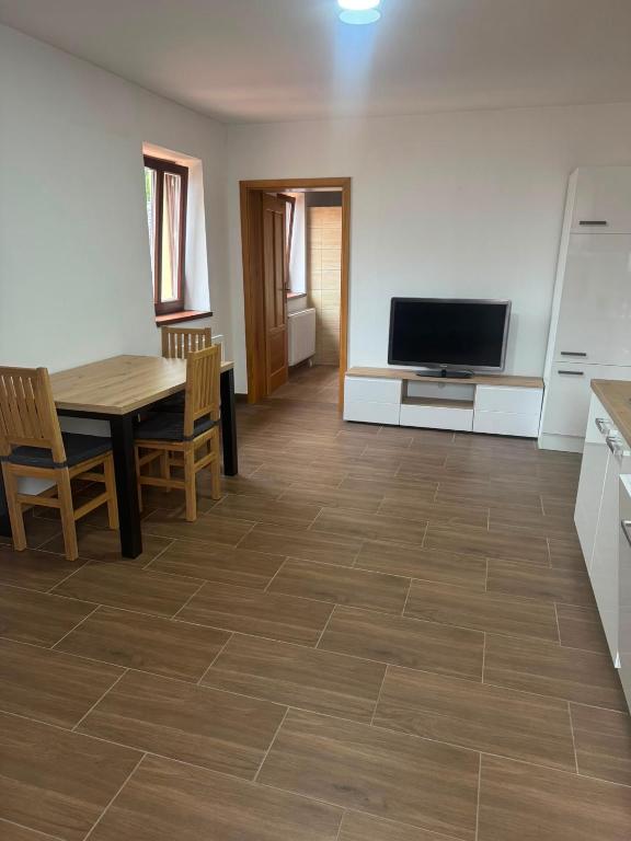 a kitchen and dining room with a table and a television at Apartmán Netolice in Netolice