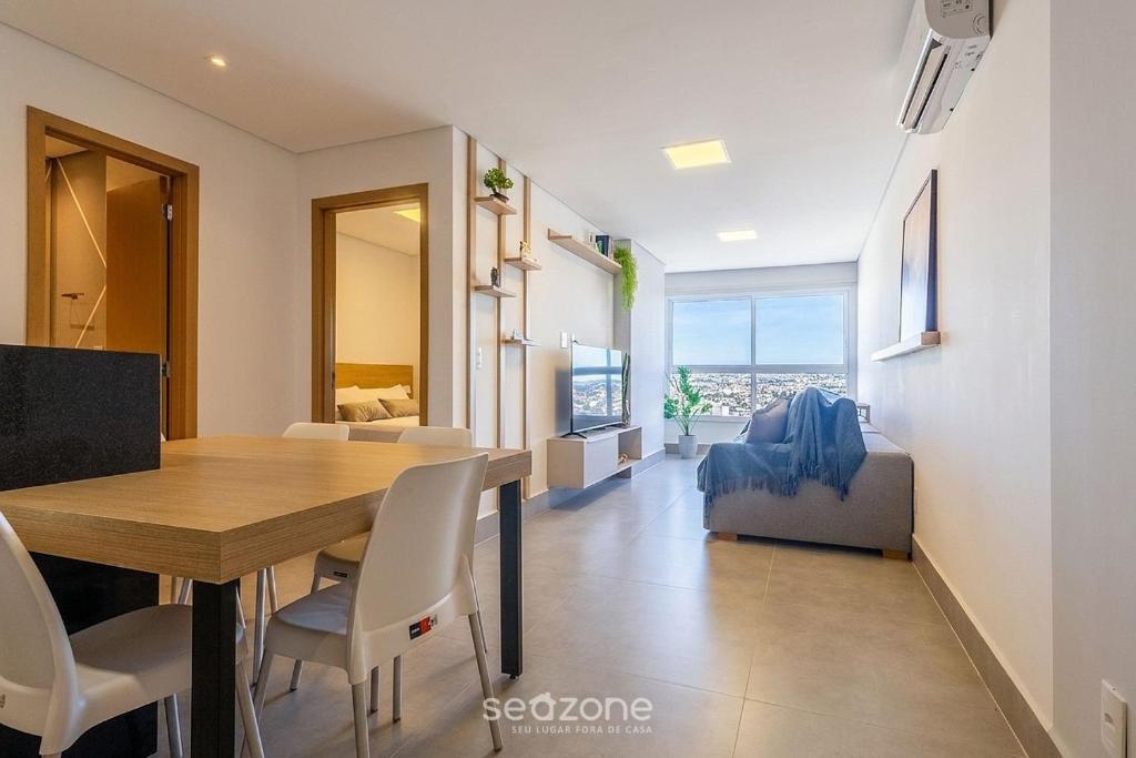 a dining room and living room with a table and chairs at Apto w/ A/C in Anápolis Downtown GRLB1802 in Anápolis
