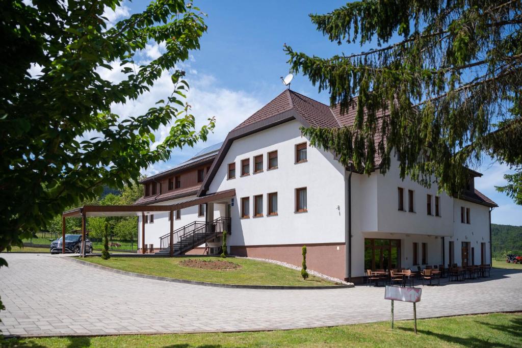 a large white building with a gambrel roof at B&B Villa Angy in Korenica