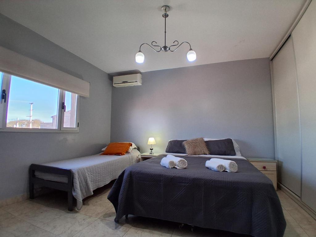 a bedroom with two beds and a window at Dos Lapachos in San Fernando del Valle de Catamarca
