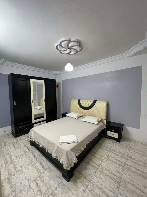 a bedroom with a large bed and a mirror at Vacation home in Kelibia