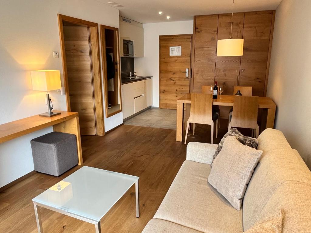 a living room with a couch and a table at Alpine Apartment Andermatt in Andermatt