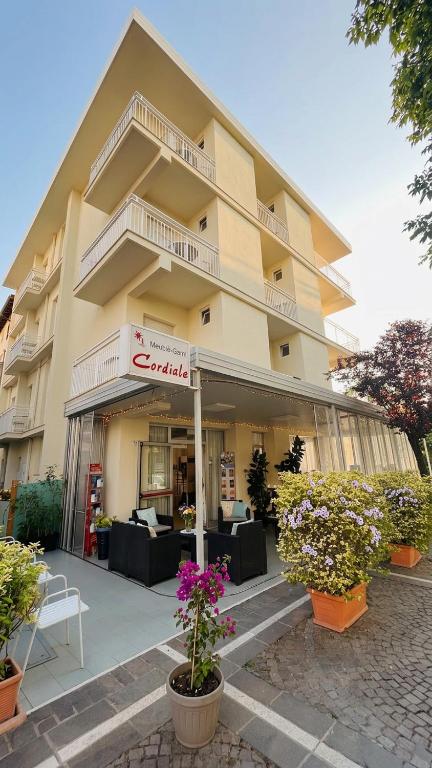 a large building with plants in front of it at B&B - Meuble' - Hotel " CORDIALE " in Misano Adriatico