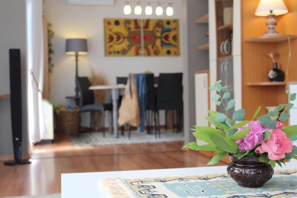 a vase with flowers on a table in a living room at Sunny Day Apartment in Pomorie