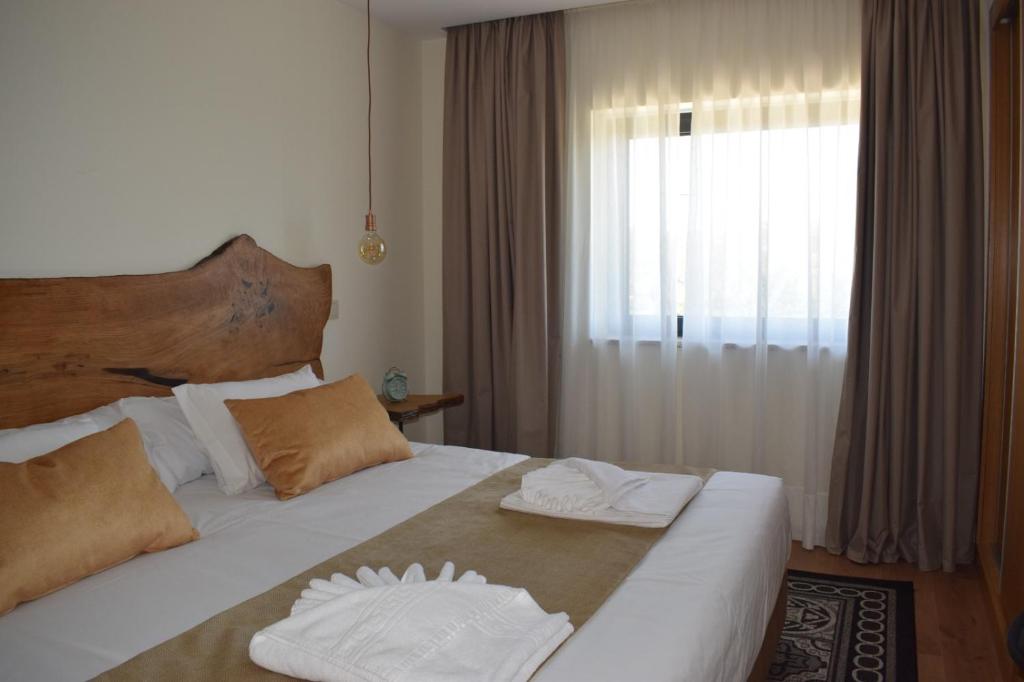 a bedroom with a large bed with two towels on it at Alojamento Madeira`s in Videmonte
