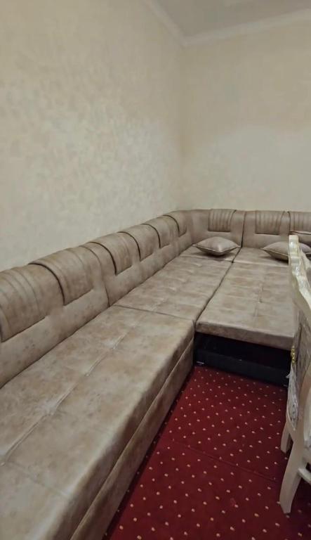 a large couch in a room with a red carpet at Khudzhand City in Khujand