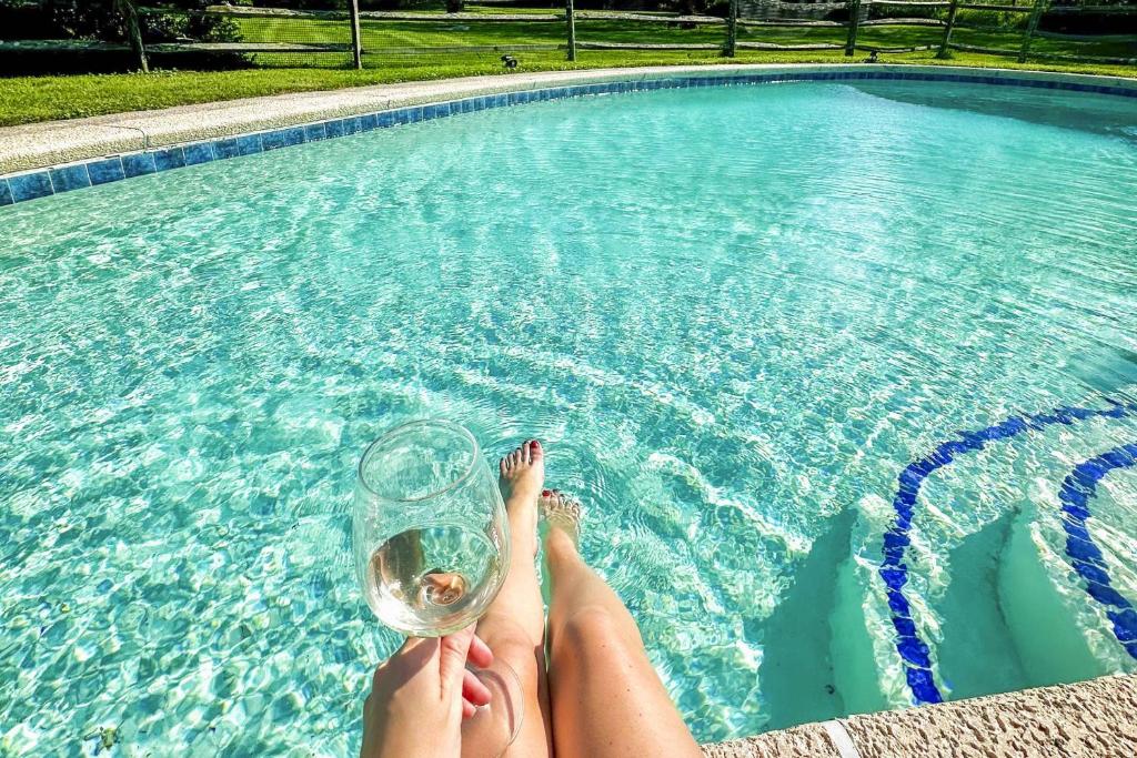 a woman holding a glass of water in a swimming pool at Bluestone Cottage in Goshen