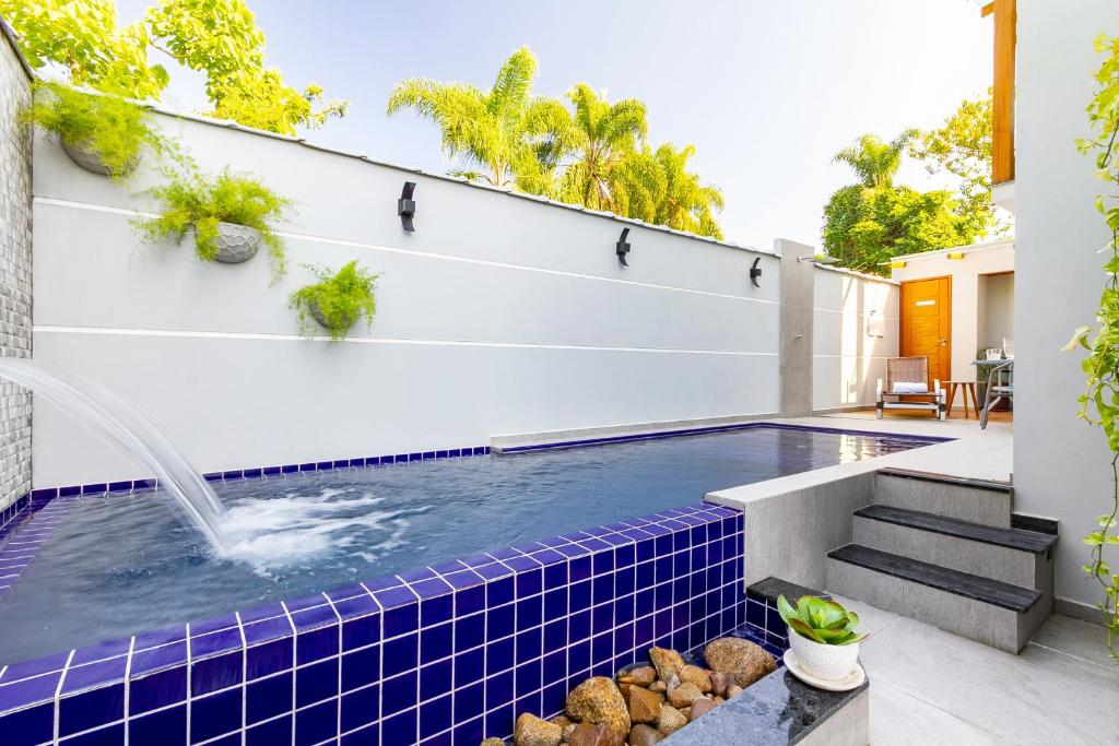 a swimming pool with a fountain in a house at Calamar Flats - Frente à Praia do Jabaquara in Paraty
